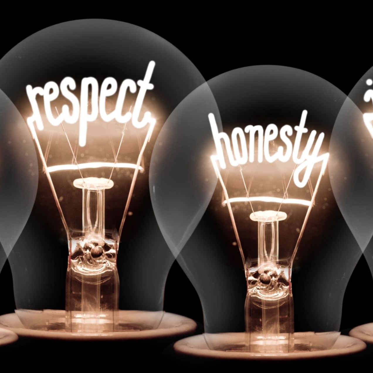 Illustration of four lightbulbs with the words ethics, respect, honesty and integrity spelt out in the filaments